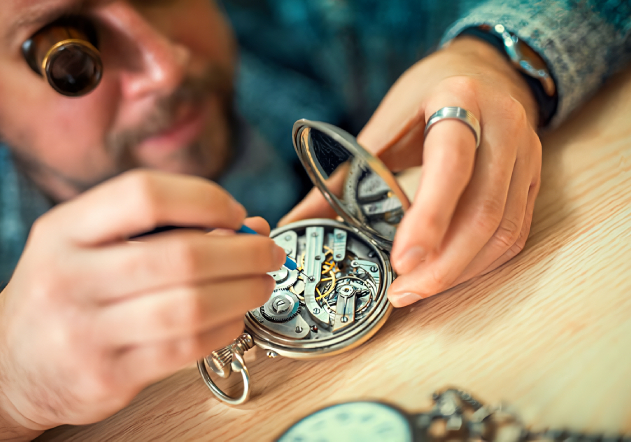 hombre arreglando un reloj